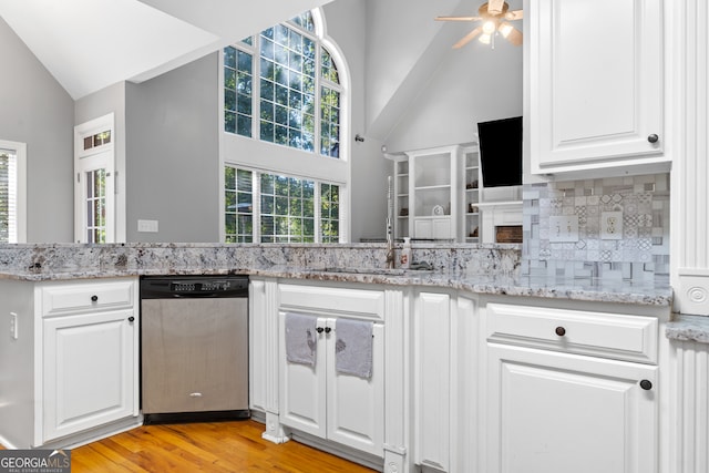 kitchen with stainless steel dishwasher, white cabinets, and plenty of natural light