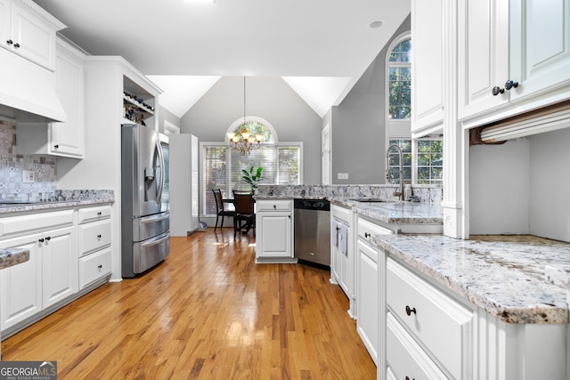 kitchen with white cabinetry, sink, pendant lighting, light hardwood / wood-style floors, and stainless steel appliances