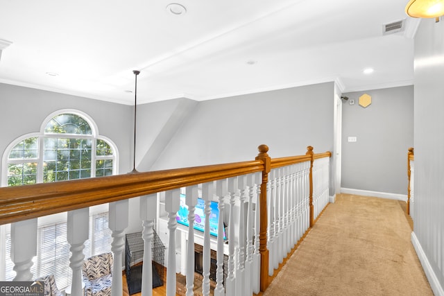 hallway featuring ornamental molding and light carpet