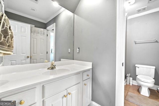 bathroom featuring vanity, toilet, ornamental molding, and wood-type flooring