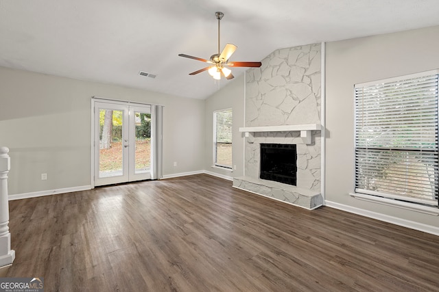 unfurnished living room featuring ceiling fan, vaulted ceiling, a high end fireplace, and dark hardwood / wood-style floors