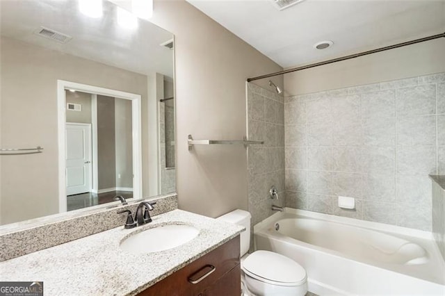 full bathroom featuring vanity, tiled shower / bath combo, and toilet