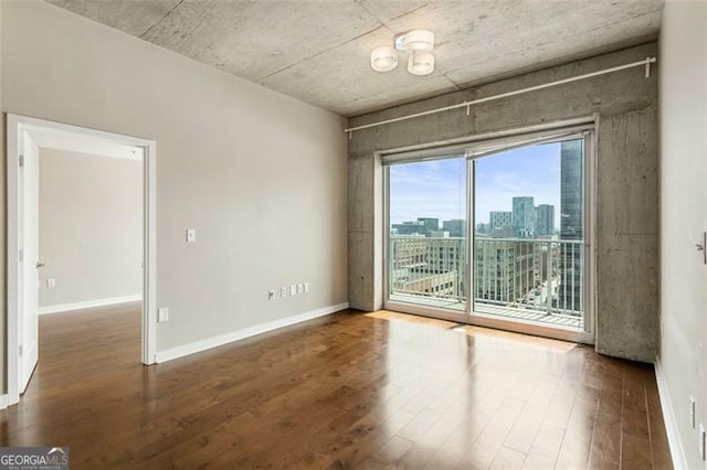 unfurnished room with dark hardwood / wood-style flooring