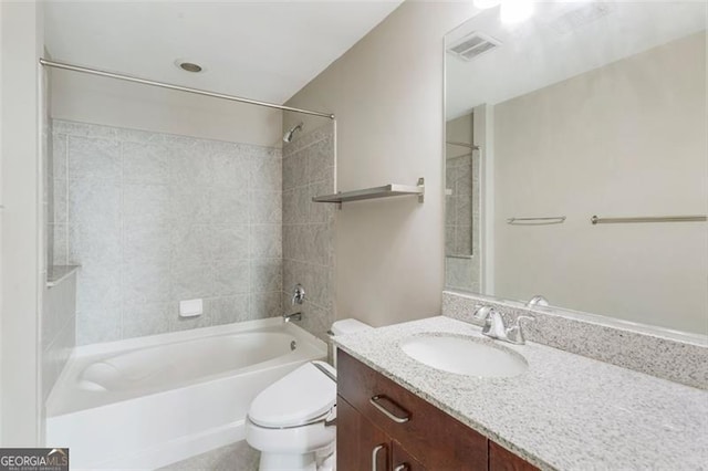 full bathroom with tiled shower / bath, vanity, and toilet