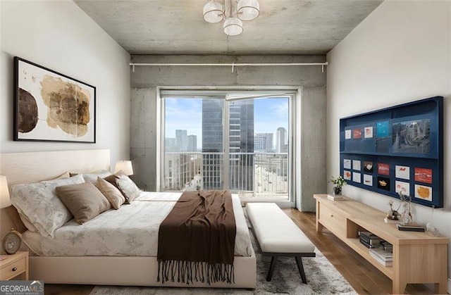 bedroom with an inviting chandelier and dark hardwood / wood-style floors