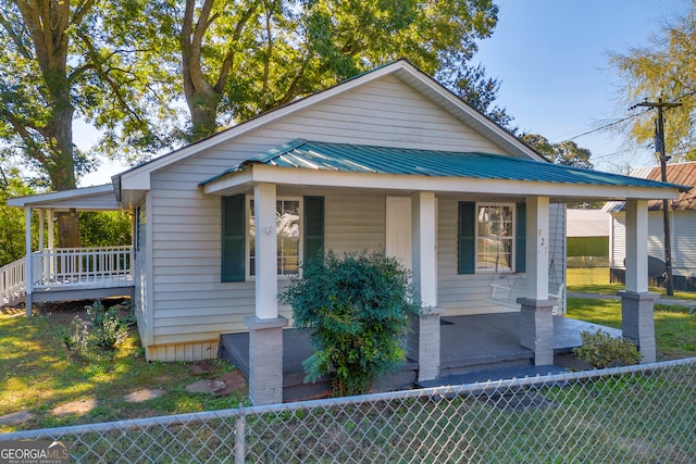 bungalow featuring covered porch and a front lawn