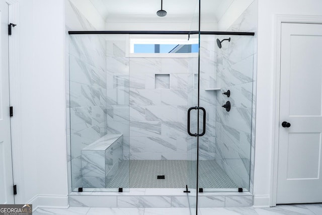 bathroom with marble finish floor, a stall shower, and crown molding