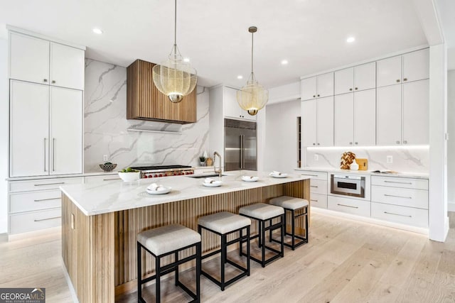 kitchen with white cabinets, an island with sink, and appliances with stainless steel finishes