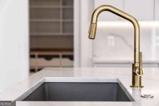 details with light stone countertops and sink