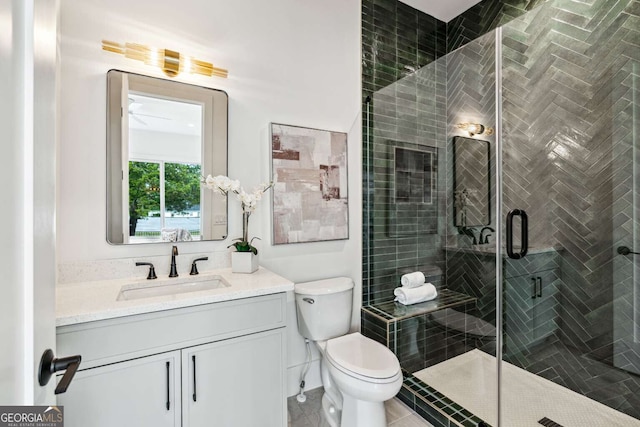 bathroom featuring tile patterned flooring, vanity, an enclosed shower, and toilet