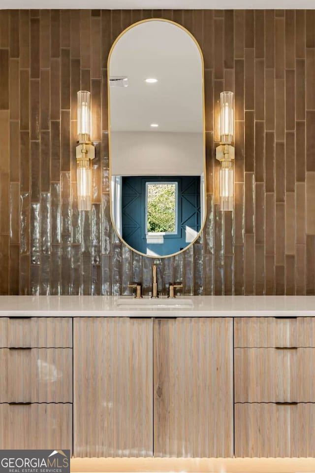 bathroom featuring tasteful backsplash and sink