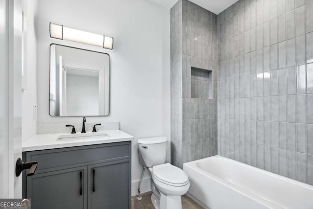 full bathroom with vanity, tiled shower / bath combo, and toilet