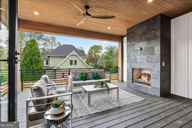 wooden terrace featuring an outdoor living space with a fireplace and ceiling fan