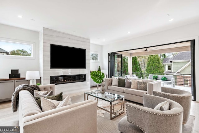 living room with a fireplace, light hardwood / wood-style flooring, and plenty of natural light