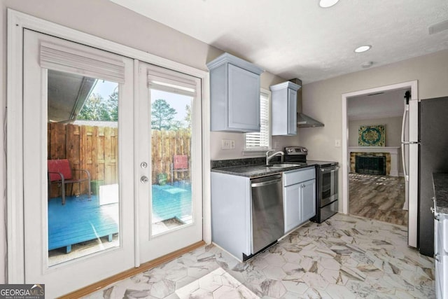 kitchen with appliances with stainless steel finishes, sink, a fireplace, and gray cabinetry