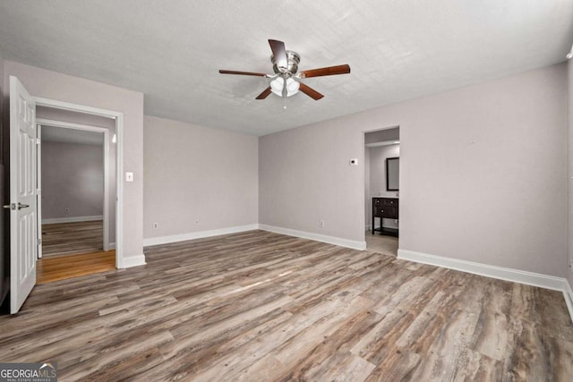 interior space with a textured ceiling, hardwood / wood-style flooring, and ceiling fan