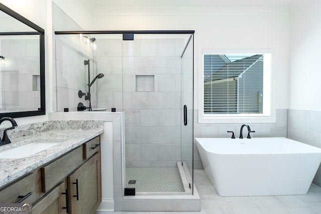 full bathroom featuring vanity, a shower stall, and a soaking tub