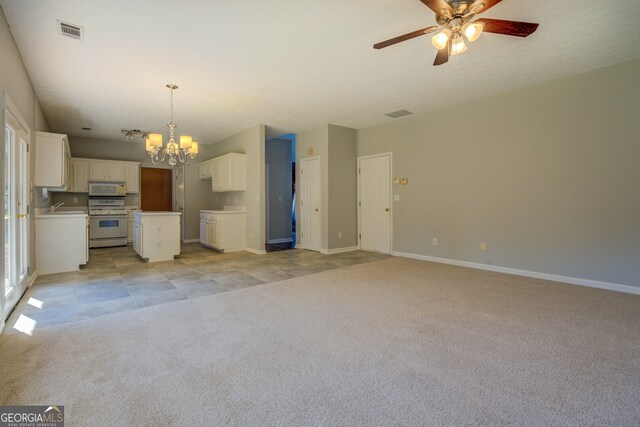 unfurnished living room with light colored carpet, sink, and ceiling fan with notable chandelier