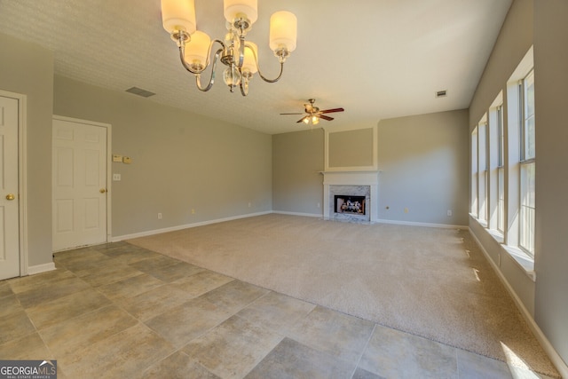 unfurnished living room with a chandelier, ceiling fan, light carpet, a fireplace, and baseboards