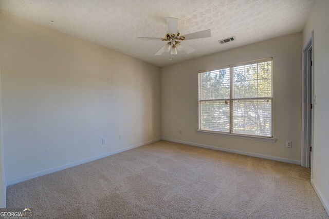 unfurnished room with light carpet, a textured ceiling, and ceiling fan