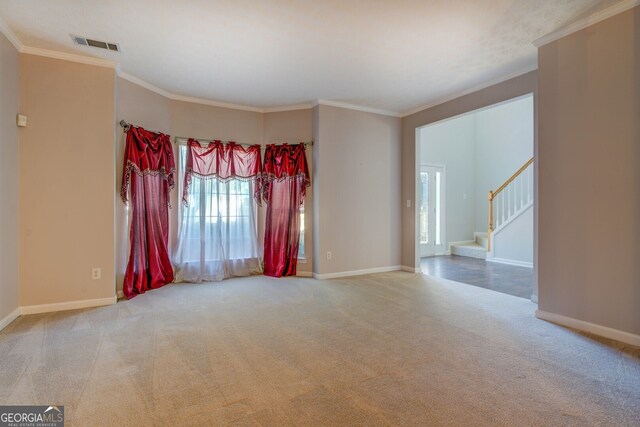 unfurnished room with ornamental molding and carpet floors