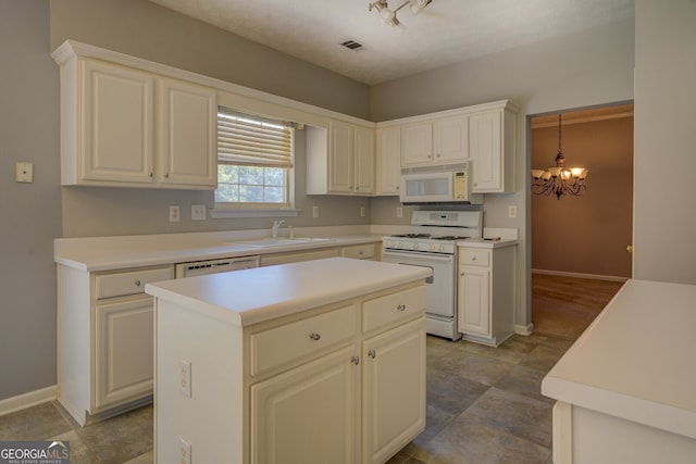 kitchen featuring white appliances, a sink, a chandelier, baseboards, and light countertops