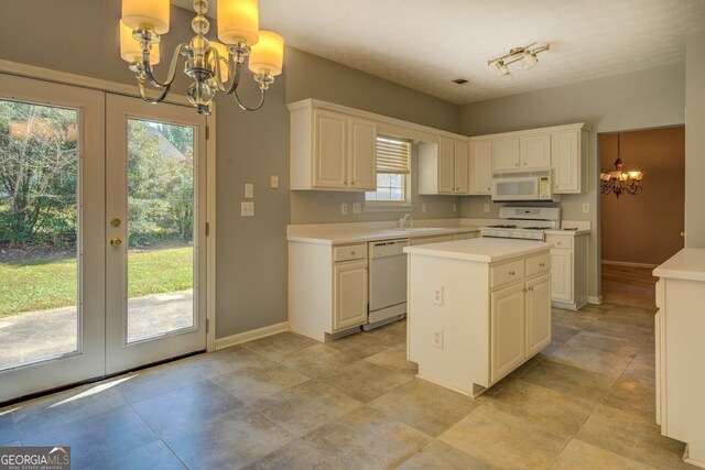 kitchen featuring white cabinets, hanging light fixtures, a kitchen island, a chandelier, and white appliances