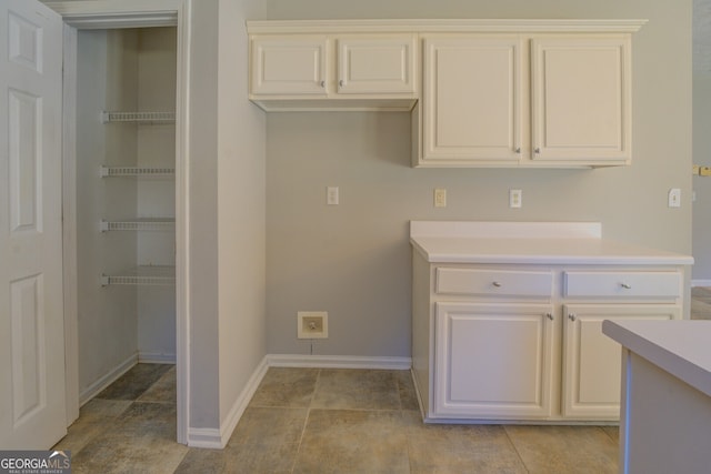clothes washing area with baseboards