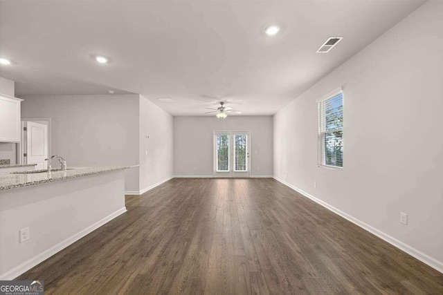 unfurnished living room featuring ceiling fan, dark hardwood / wood-style flooring, and sink