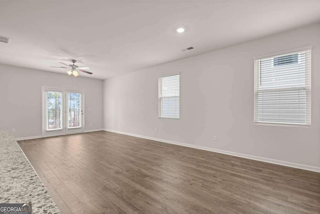 unfurnished room featuring dark wood-type flooring and ceiling fan