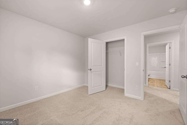 unfurnished bedroom with a closet and light carpet