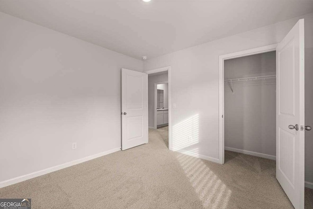 unfurnished bedroom featuring light colored carpet and a closet