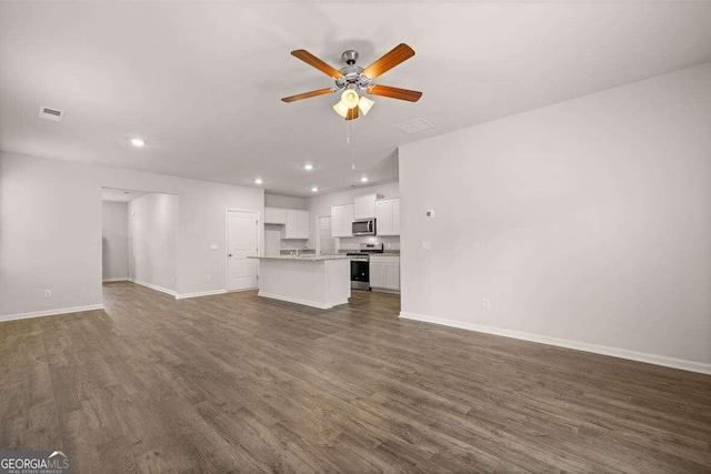 unfurnished living room with dark hardwood / wood-style floors and ceiling fan