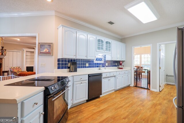 kitchen featuring white cabinetry, a textured ceiling, light hardwood / wood-style flooring, ornamental molding, and stainless steel appliances