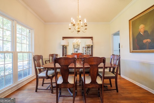 dining space with ornamental molding, hardwood / wood-style floors, and a chandelier