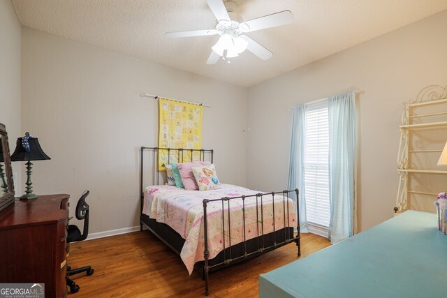 bedroom featuring hardwood / wood-style floors, a textured ceiling, and ceiling fan