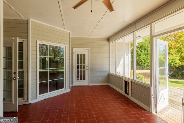 unfurnished sunroom with ceiling fan and a healthy amount of sunlight