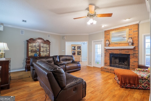 living room featuring a wealth of natural light, ornamental molding, a fireplace, and wood-type flooring