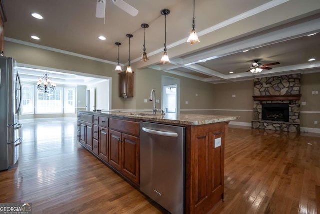 kitchen with appliances with stainless steel finishes, a wealth of natural light, a center island with sink, and dark hardwood / wood-style flooring