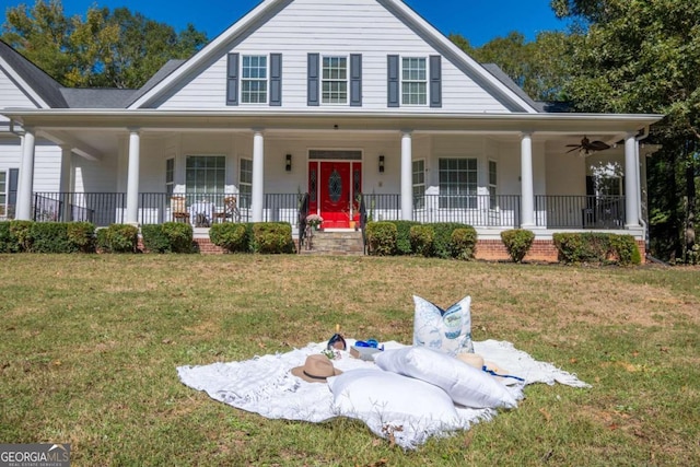 farmhouse-style home with a front yard, ceiling fan, and a porch