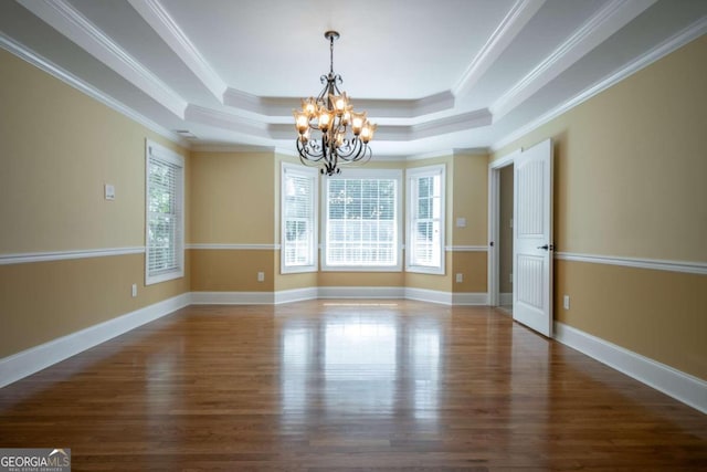 empty room with dark wood-type flooring, crown molding, and a raised ceiling