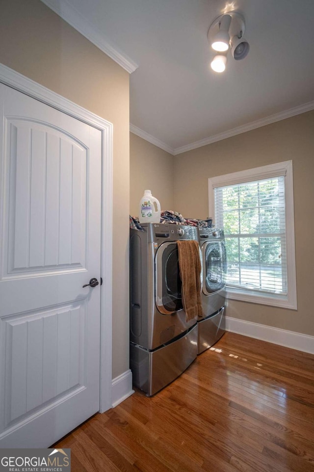 washroom featuring washer and dryer, crown molding, and wood-type flooring