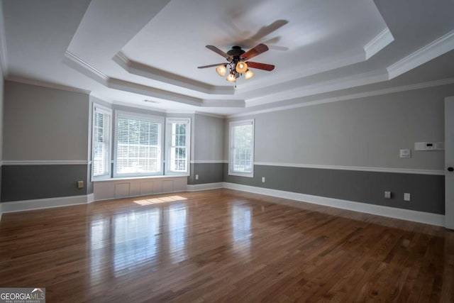 empty room featuring ornamental molding, hardwood / wood-style floors, and a tray ceiling