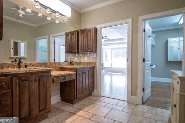 kitchen featuring sink, crown molding, light stone counters, and ceiling fan