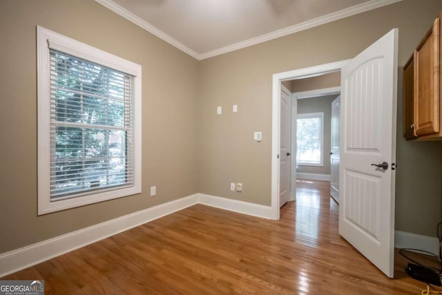 empty room featuring light hardwood / wood-style floors and ornamental molding