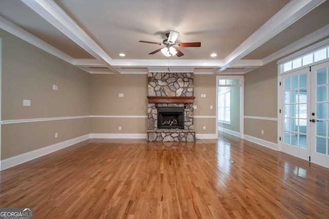 unfurnished living room featuring french doors, coffered ceiling, hardwood / wood-style flooring, and a fireplace