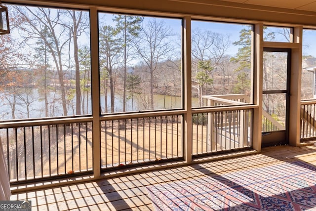 unfurnished sunroom with a water view