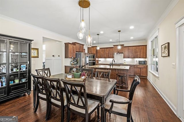 dining area with ornamental molding, sink, and dark hardwood / wood-style floors