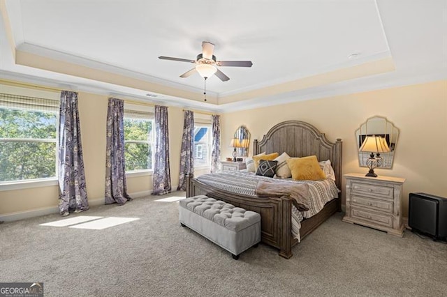 bedroom with ornamental molding, a raised ceiling, light carpet, and baseboards