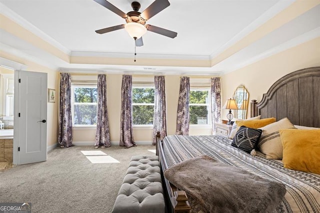 bedroom featuring baseboards, a tray ceiling, light colored carpet, and crown molding